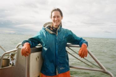 Lillian Saul standing on a fishing boat